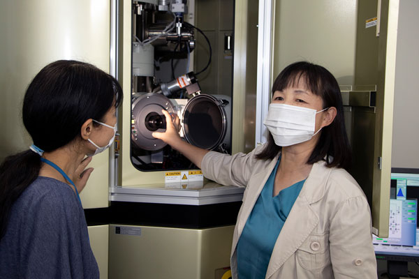Picture of Yu talking to her labmate