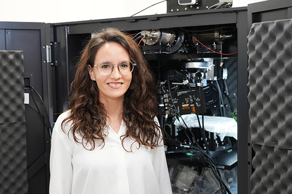 picture of Cristina Risueno Segovia in front of a microscope