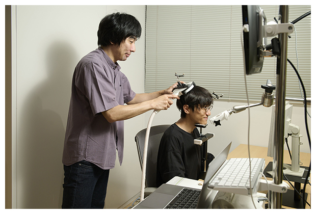 脳活動を経頭蓋磁気刺激法（TMS)で計測している写真