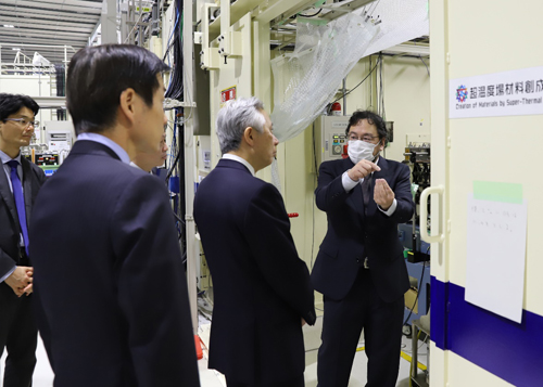 SPring-8共用ビームラインBL47XUにて上杉 主席研究員から説明を受けられる盛山 大臣の写真