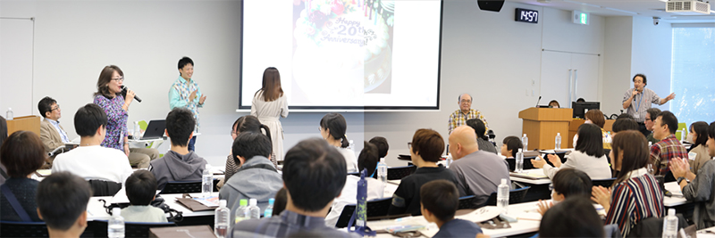 ハッピーバースデー、ニホニウム♪を歌う櫻井 博儀RNCセンター長と参加者の皆さんの様子