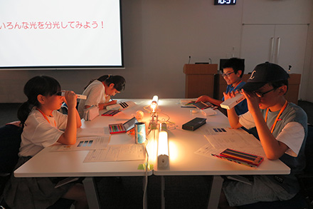 分光器でランプのスペクトルを観察している様子