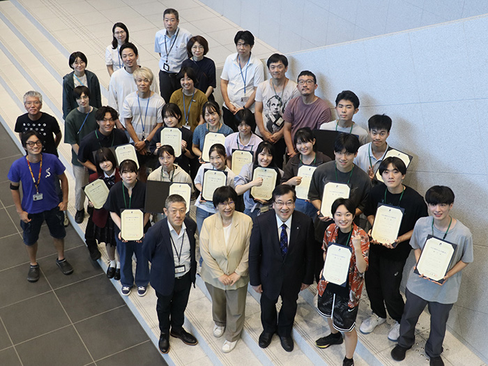 修了証を手に記念撮影の写真