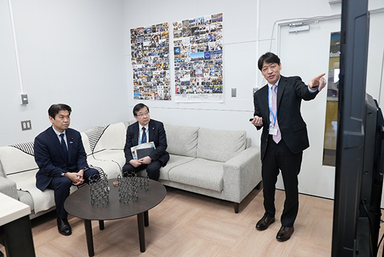 分子ナノカーボン合成・触媒技術について説明を受けられる松本 大臣の写真