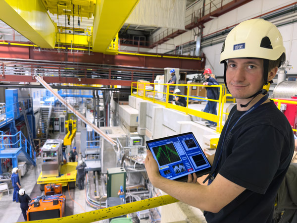 Picture of a researcher monitoring the condition of 100 protons in a trap 